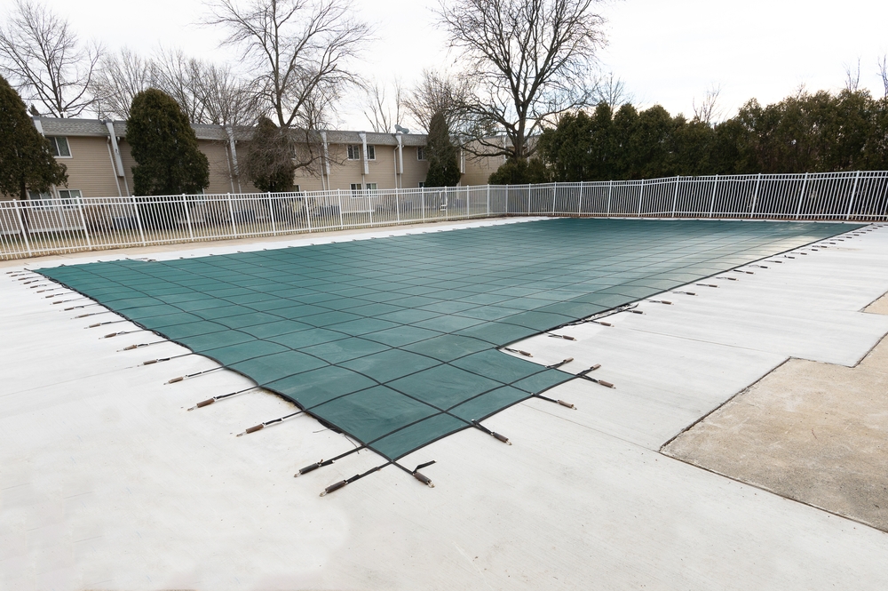 a winterized pool with a pool cover